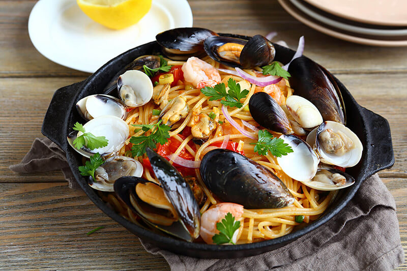 Menu featuring pasta dish with seafood, highlighting fresh ingredients