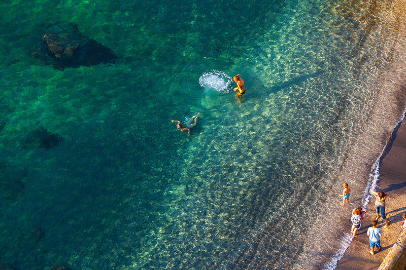 Guests swimming in clear blue water by the seaside
